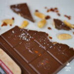 Tablette de chocolat au lait, cacahuètes, caramel et fleur de sel ouverte